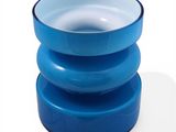 a blue glass vase sitting on top of a white table