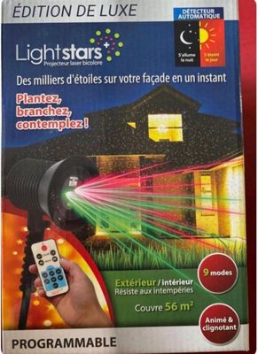 une photo d'une personne tenant une télécommande devant une maison