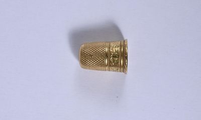 gros plan d'une bague en or sur une surface blanche