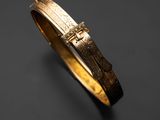 Gros plan sur un bracelet en or orné d'une croix