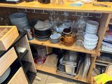 a wooden shelf filled with dishes and glasses