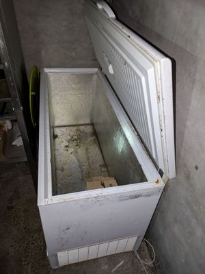 un réfrigérateur blanc ouvert, dans un coin de la pièce