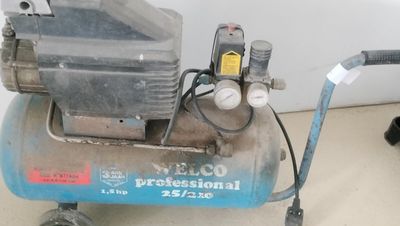 un petit compresseur d'air posé par terre à côté d'un chat