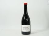une bouteille de vin posée sur une table blanche