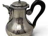 a silver teapot with a black handle on a white background