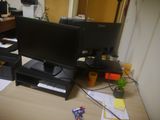 a computer desk with two monitors and a printer on it