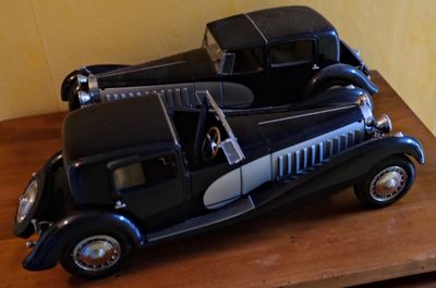 une maquette de voiture noire et argentée posée sur une table en bois