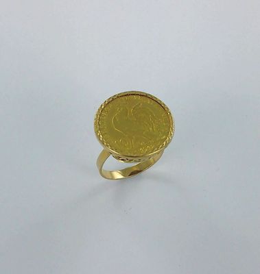 l'image d'une bague en or sur laquelle se trouve une pièce de monnaie