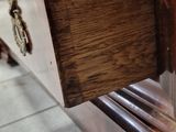 a close up of a wooden dresser on a tile floor
