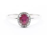 Gros plan sur une bague sertie d'un rubis et de diamants, sur fond blanc