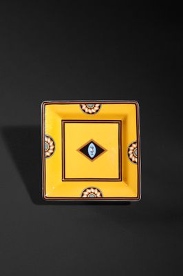 an image of a yellow square plate with a blue eye on it