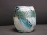 a white vase with a blue and green design on it