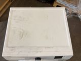 a white box sitting on the floor next to some boxes