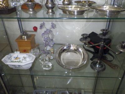une vitrine en verre contenant de nombreux objets en argent