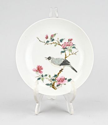 une image représentant une assiette sur laquelle sont peints un oiseau et des fleurs