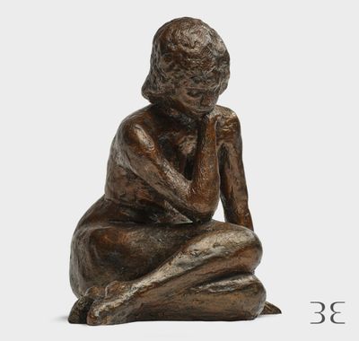 un gros plan sur la statue d'une personne assise par terre