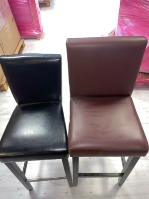 une paire de tabourets de bar en cuir noir et marron dans un magasin