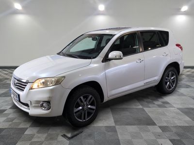 La Toyota RAV blanche est garée sur un sol en carrelage à damier.