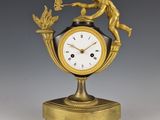 une horloge en or surmontée d'une statue