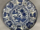 a blue and white plate with flowers and birds on it
