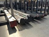 several steel pipes are stacked up in a large warehouse