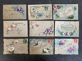 plusieurs vieilles cartes postales représentant des fleurs et des oiseaux, posées sur une table