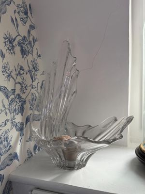 un saladier en verre posé sur une table près d'une fenêtre
