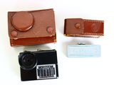 a small camera and a case on a white surface