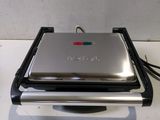 a silver and black grill on a white counter