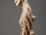 an antique statue of a woman holding a bird on a table