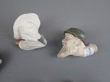 three figurines of a man with a hat and a pipe