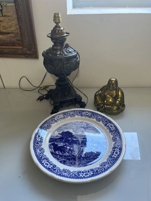 a blue and white plate sitting on a table next to a lamp