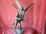 statue en bronze représentant un homme et une femme s'étreignant sur un rocher