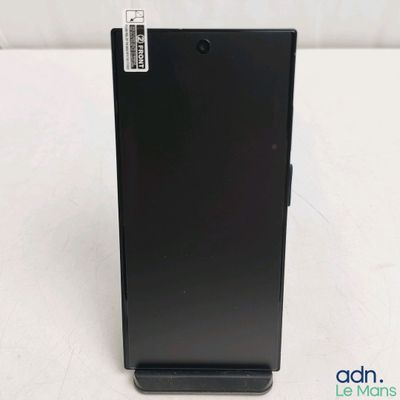 le dos d'un téléphone portable noir posé sur une table blanche