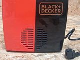 a small black and red clock sitting on a table