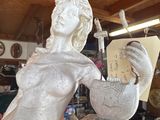a statue of a woman reading a book in a shop