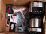 une boîte contenant une cafetière, une montre et d'autres objets