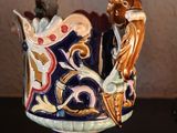 a vase with a bird on it sitting on a table