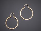 a pair of gold hoop earrings on a black background