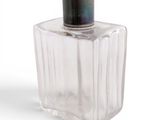 a clear glass bottle with a black top