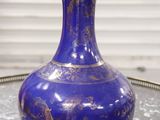 un vase bleu posé sur un plateau, lui-même posé sur une table