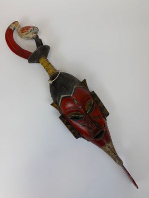 une image d'un masque en bois accroché au mur