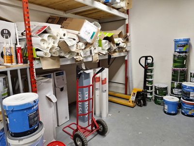 une pièce où les étagères sont remplies de pots de peinture et de matériel