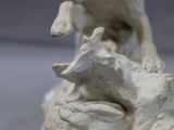a statue of a cow and a calf on a rock