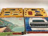 trois trains miniatures dans leurs boîtes, empilés les uns sur les autres sur une table