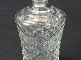 a glass bottle that is sitting on a black surface