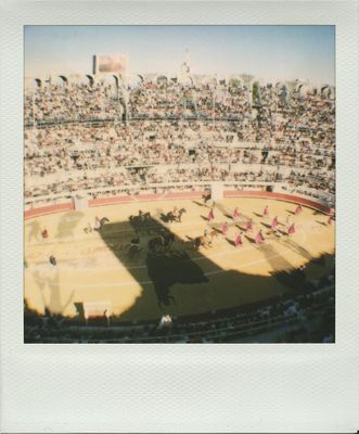 une photo d'une corrida dans un stade, avec des spectateurs