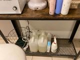 une étagère sur laquelle sont posées des bouteilles d'eau et d'autres produits d'entretien