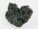 un gros plan d'un morceau de roche verte posé sur une surface blanche