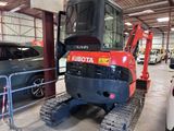 a picture of a red and black vehicle parked in a garage
